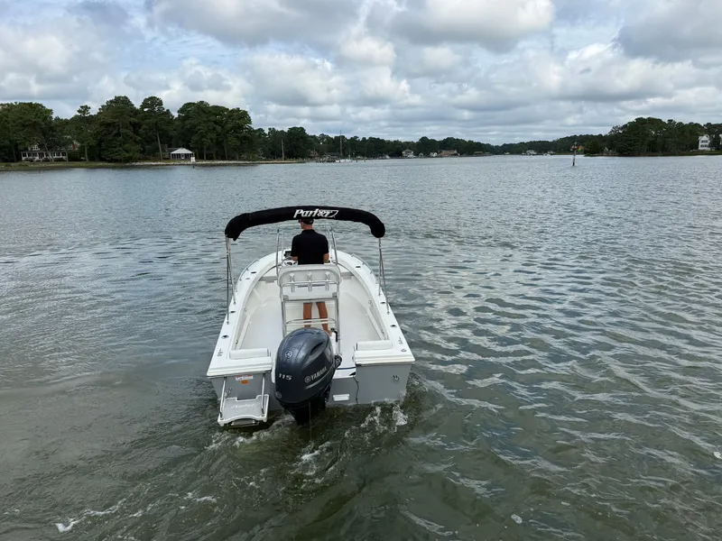 Slide: The Image of A 2023 Parker 1801 Center Console boat navigates calm waters under a cloudy sky. - 14