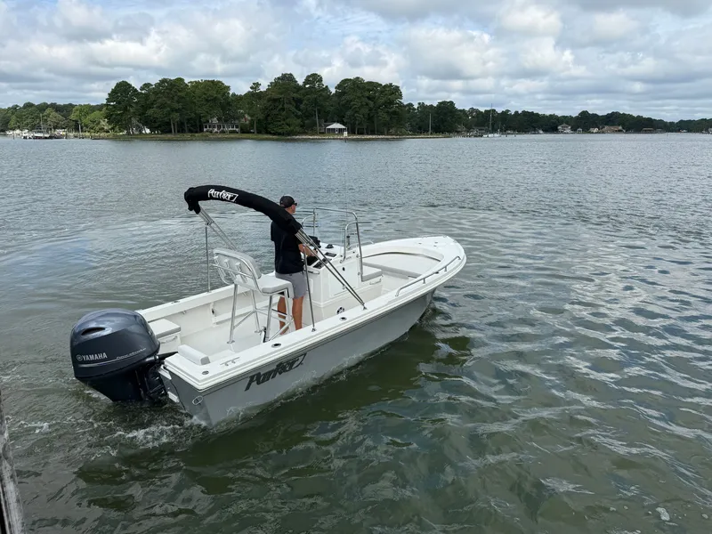Slide: The Image of A 2023 Parker 1801 Center Console boat on calm waters with a wooded shoreline. - 13