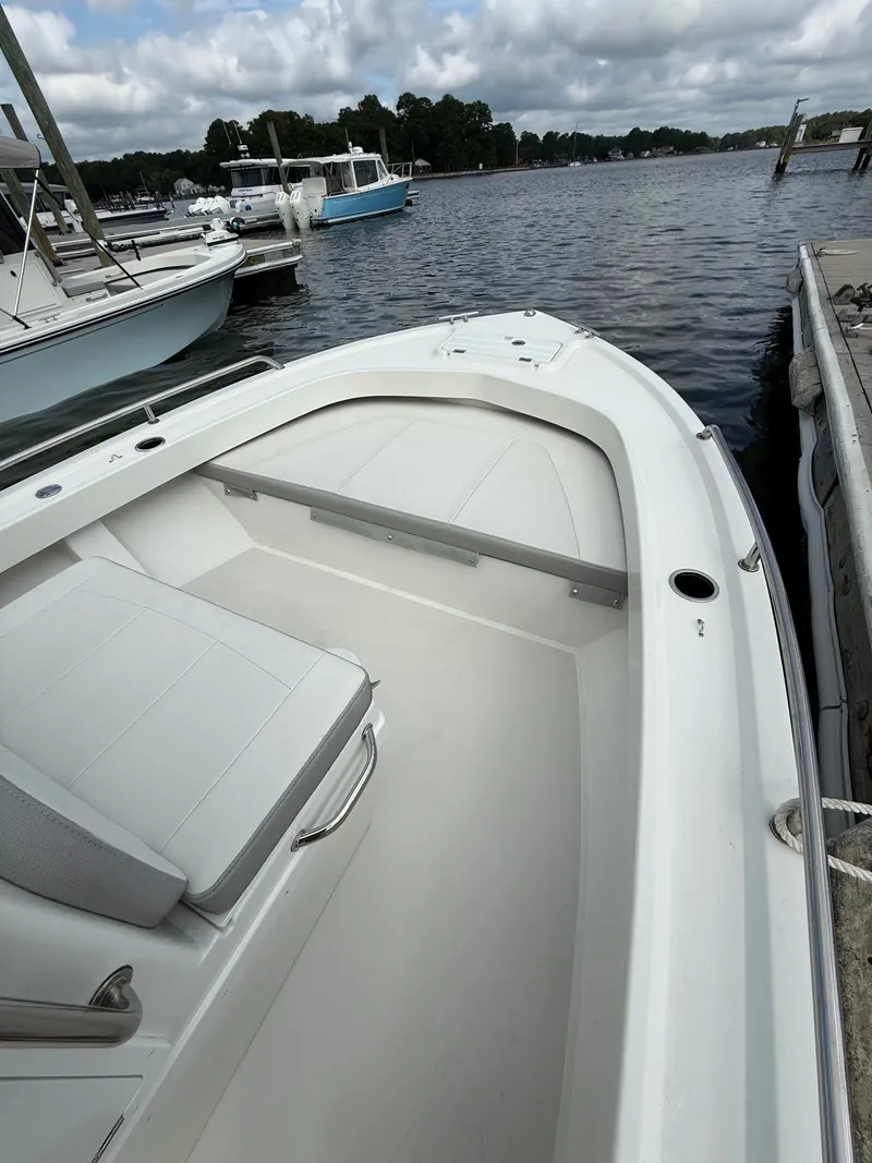 Slide: The Image of A 2023 Parker 1801 Center Console boat docked. It features white seating and a spacious deck. - 17