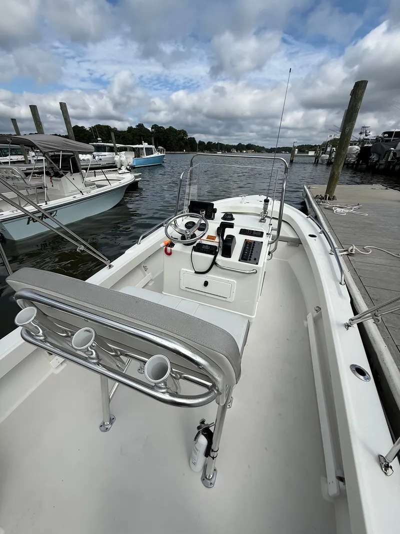 Slide: The Image of A 2023 Parker 1801 Center Console boat docked. It features an open helm and rod holders. - 25