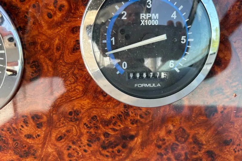 Slide: The Image of Close-up of a 2005 Formula 34 Performance Cruiser RPM gauge on a wood grain dashboard. - 12