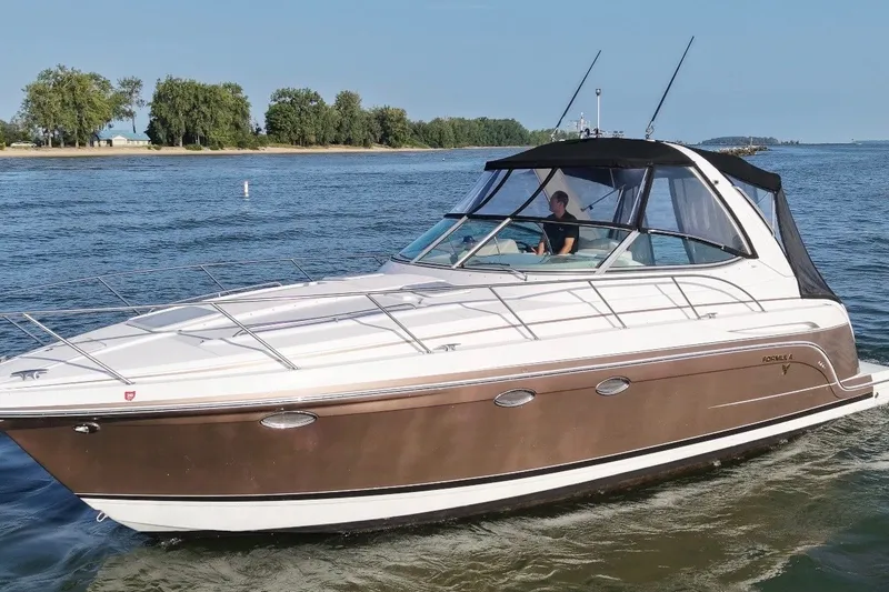 The Image of 2005 Formula 34 Performance Cruiser on a serene lake with lush green shoreline. - 0