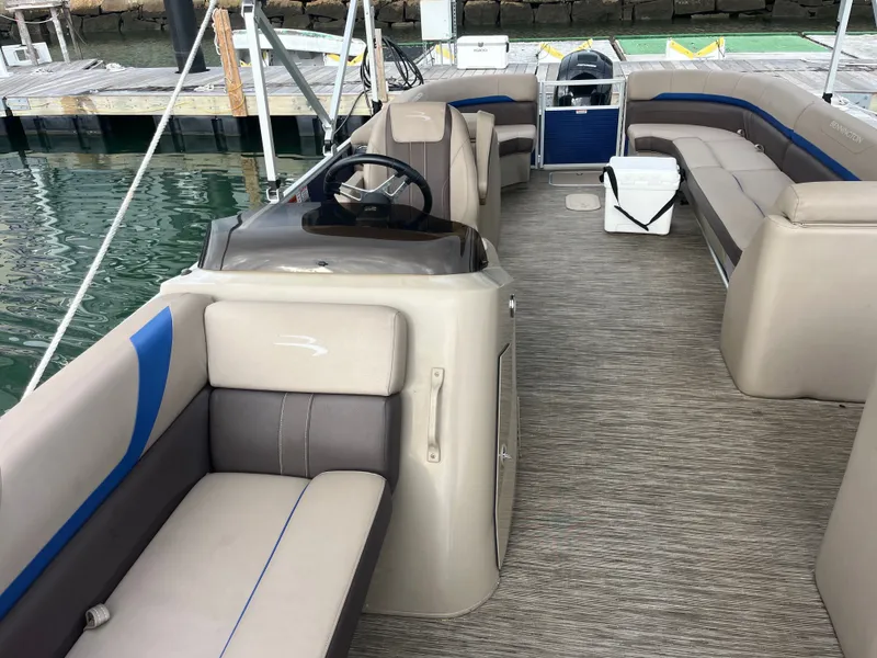 Slide: The Image of The image shows the interior of a 2022 Bennington 23SXSRC pontoon boat with beige and blue seating. - 8