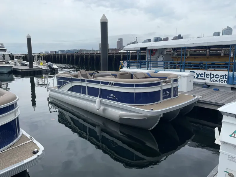 The Image of A 2022 Bennington 23SXSRC pontoon boat docked in a calm harbor. - 0