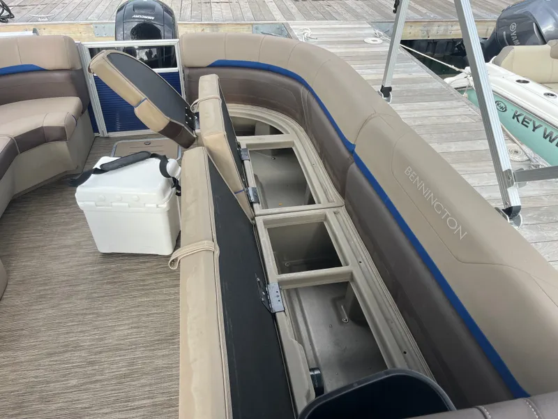 Slide: The Image of The image shows the interior of a Bennington 23SXSRC pontoon boat with seating and storage. - 9
