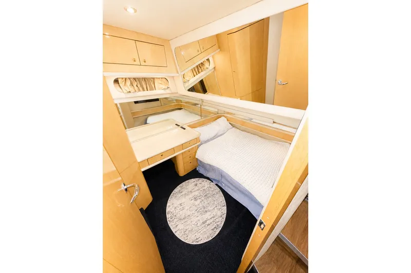 Slide: The Image of Cozy cabin interior of 2001 Sea Ray 560 Sedan Bridge yacht with bed and storage. - 24