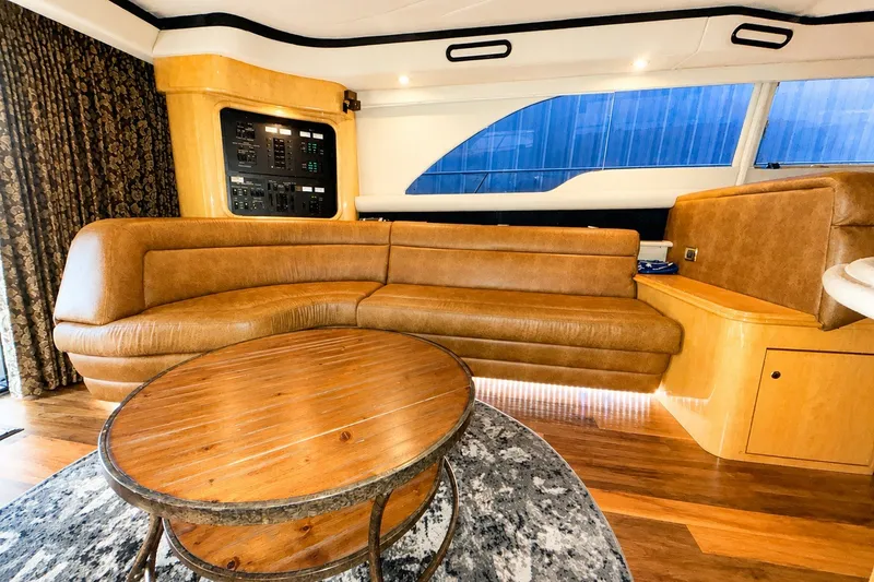 Slide: The Image of Luxurious interior of 2001 Sea Ray 560 Sedan Bridge with leather seating and wooden table. - 17