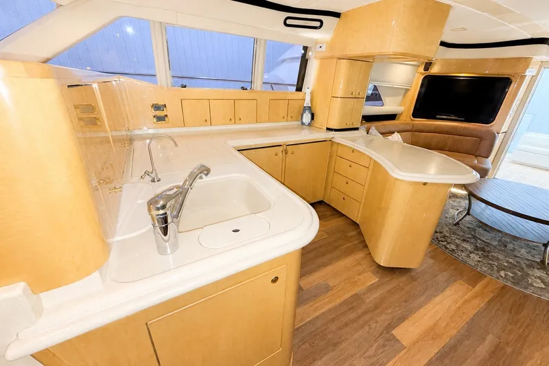 Slide: The Image of Luxurious interior of 2001 Sea Ray 560 Sedan Bridge yacht with modern kitchen and seating area. - 19