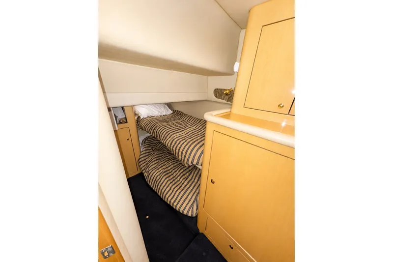 Slide: The Image of Interior cabin of 2001 Sea Ray 560 Sedan Bridge with bunk beds and wooden cabinetry. - 26