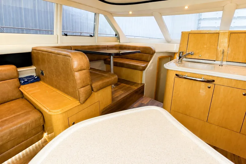 Slide: The Image of Interior of 2001 Sea Ray 560 Sedan Bridge with leather seating and wooden cabinetry. - 20