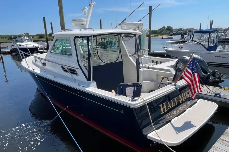 The Image of 2005 Back Cove 29 boat docked, featuring a sleek design and American flag. - 0