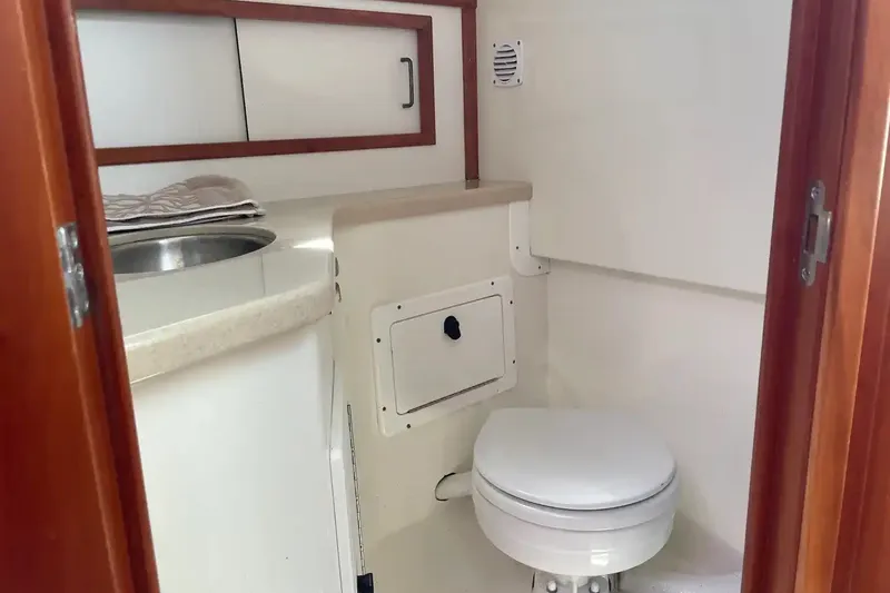 Slide: The Image of 2005 Back Cove 29 boat bathroom with sink, toilet, and storage cabinets. - 15