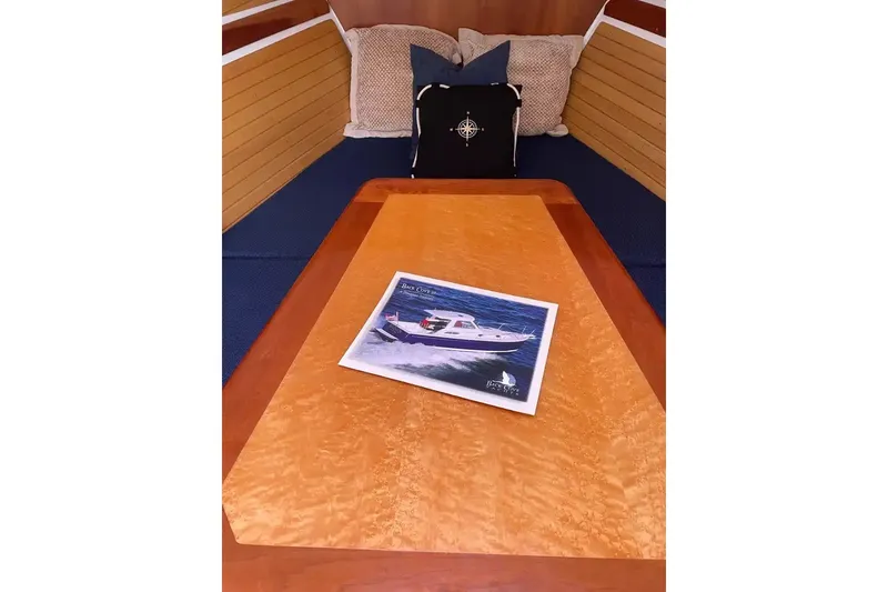 Slide: The Image of 2005 Back Cove 29 cabin interior with brochure on wooden table. - 14