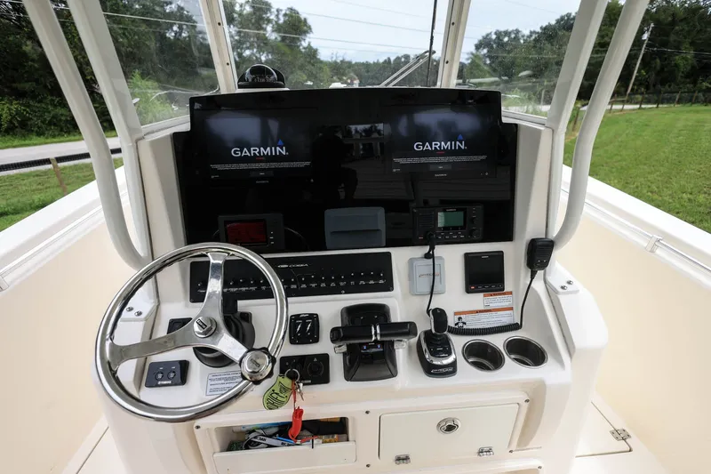 Slide: The Image of 2020 Cobia 301 Center Console helm with Garmin displays and steering wheel. - 16
