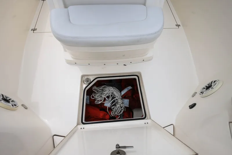 Slide: The Image of 2020 Cobia 301 Center Console boat storage compartment with ropes and life jackets. - 28