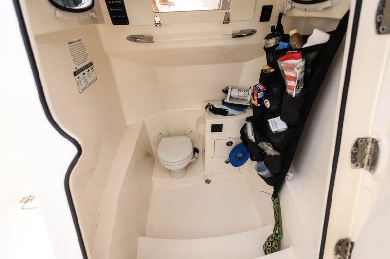 Slide: The Image of 2020 Cobia 301 Center Console boat interior with toilet and storage. - 26
