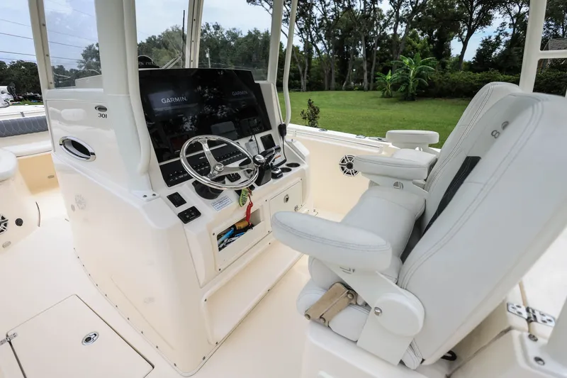 Slide: The Image of 2020 Cobia 301 Center Console boat interior with steering wheel and Garmin display. - 14