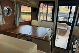 Slide: The Image of Interior of 2026 Ranger Tugs R-27, featuring a cozy dining area with wooden table. - 9