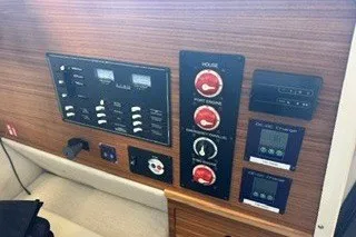 Slide: The Image of Control panel of 2026 Ranger Tugs R-27 boat with various switches and gauges. - 12