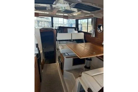 Slide: The Image of Interior of 2026 Ranger Tugs R-27, featuring a cozy dining area with wooden table and seating. - 8