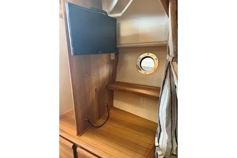 Slide: The Image of 2026 Ranger Tugs R-27 interior with TV and porthole window. - 14