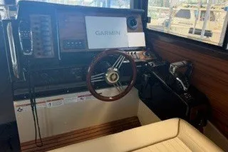 Slide: The Image of 2026 Ranger Tugs R-27 boat interior with Garmin navigation system and wooden steering wheel. - 10