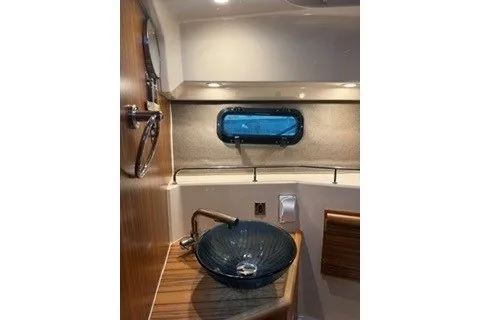Slide: The Image of 2026 Ranger Tugs R-27 bathroom with modern sink and porthole window. - 17