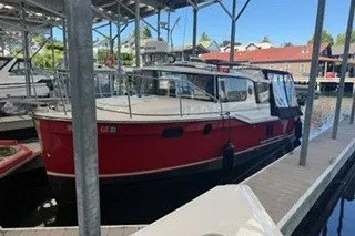 Slide: The Image of 2026 Ranger Tugs R-27 boat docked in a marina under a clear blue sky. - 2