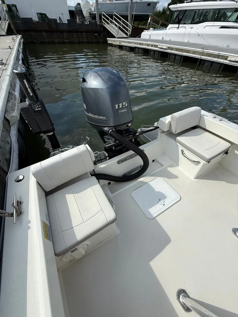 Slide: The Image of A 2021 Parker 1801 Center Console boat with a 115 HP outboard motor, docked in the water. - 15