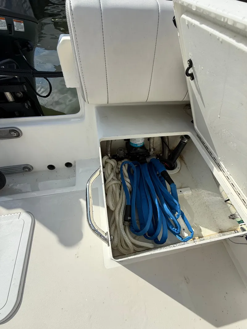 Slide: The Image of An open storage compartment on a Parker 1801 Center Console boat reveals ropes and straps. - 18