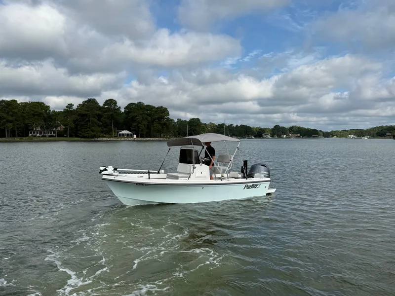 Slide: The Image of A 2021 Parker 1801 Center Console boat cruising on calm waters under a cloudy sky. - 21