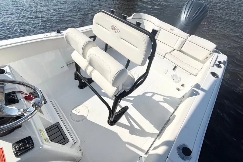 Slide: The Image of 2022 Sea Hunt Ultra 234 boat interior with seating and steering wheel on water. - 9