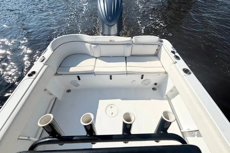 Slide: The Image of 2022 Sea Hunt Ultra 234 boat interior with seating and rod holders on the water. - 11