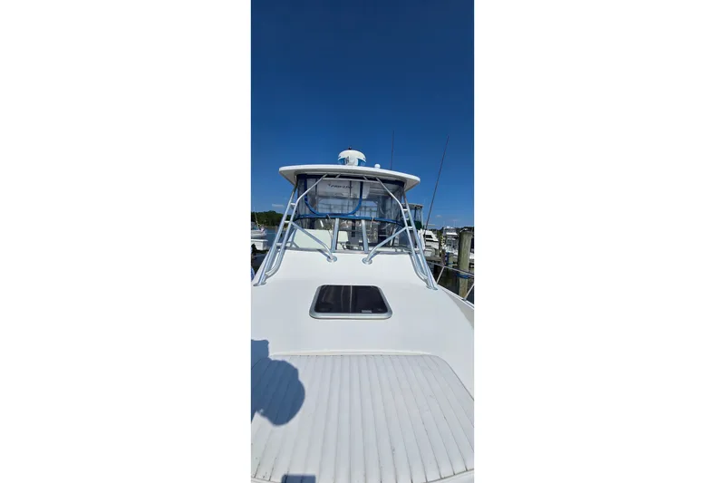 Slide: The Image of 2004 PROLINE 30 Express Walk boat, front view, docked under clear blue sky. - 7