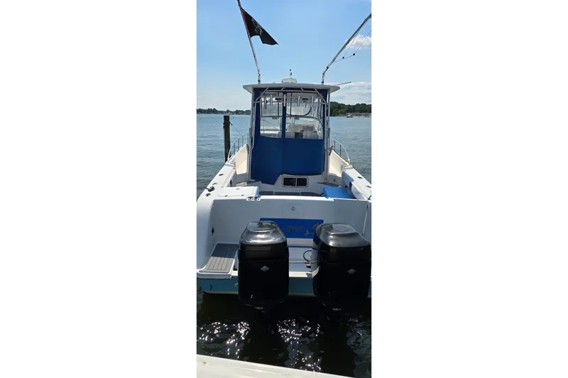 Slide: The Image of 2004 PROLINE 30 Express Walk boat with dual outboard motors on a sunny day. - 2