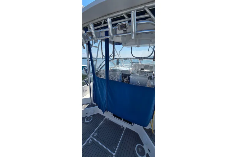 Slide: The Image of 2004 PROLINE 30 Express Walk boat with blue canopy and sleek interior design. - 4