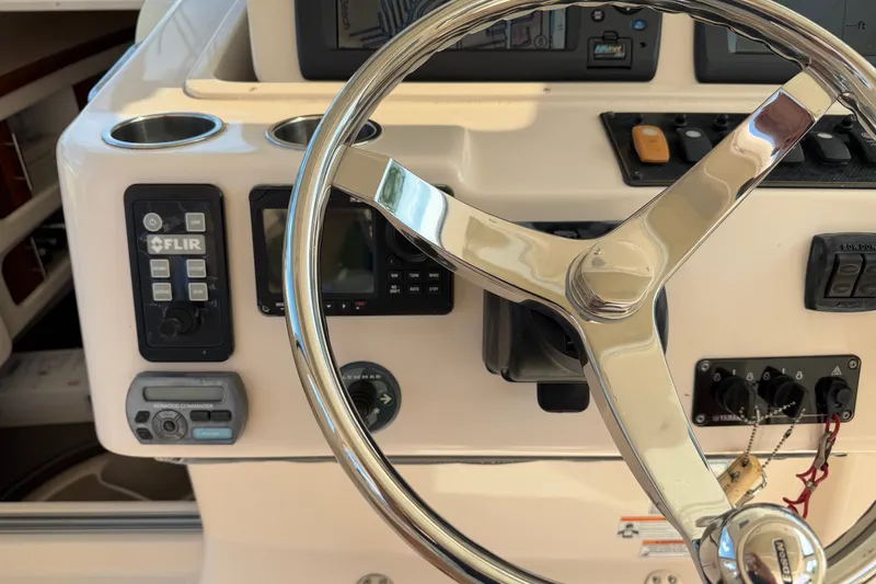 Slide: The Image of Steering wheel and controls of a 2009 Grady-White Express 360 boat cockpit. - 10