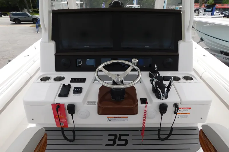 Slide: The Image of 2027 Regulator 35 boat helm with steering wheel, dual screens, and control panel. - 2