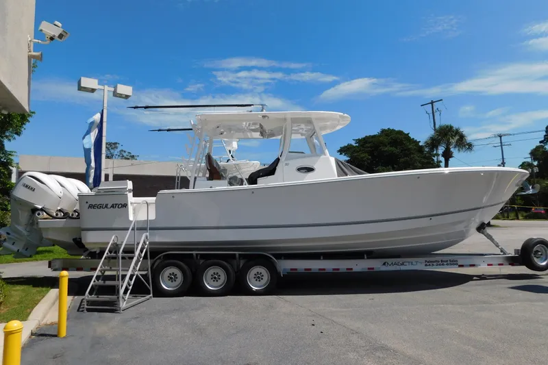 Slide: The Image of 2027 Regulator 35 boat on trailer, parked outdoors under clear blue sky. - 74