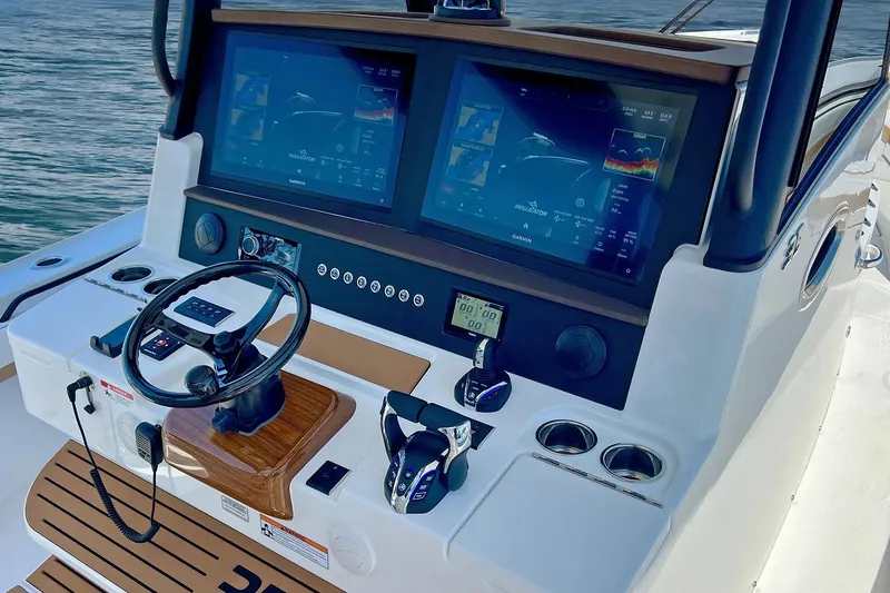 Slide: The Image of Manufacturer Provided Image: 2026 Regulator 35 boat dashboard with dual Garmin displays and steering wheel. - 79