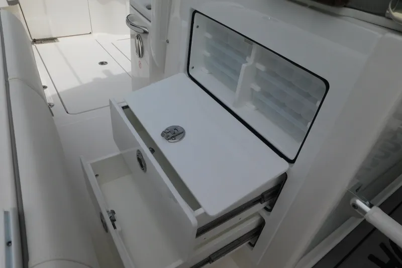 Slide: The Image of 2027 Regulator 35 boat interior with open storage compartments and sleek white design. - 44