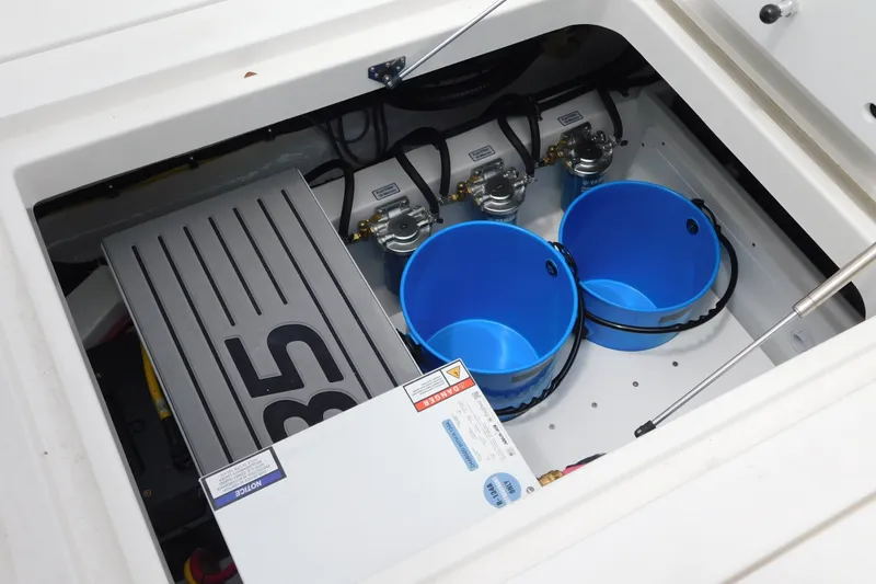 Slide: The Image of Interior view of 2027 Regulator 35 boat compartment with blue buckets and equipment. - 24