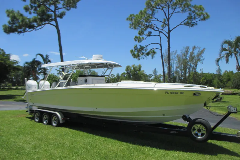 The Image of 2007 Marlago FS 35 Cuddy boat on trailer, parked on grass under clear blue sky. - 0