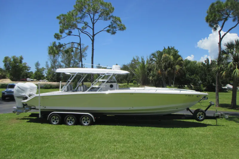 Slide: The Image of 2007 Marlago FS 35 Cuddy boat on trailer, parked on grass under clear blue sky. - 4