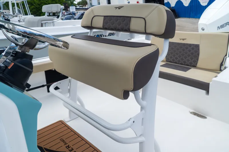Slide: The Image of 2021 Tidewater 2300 Carolina Bay boat interior with beige seating and steering wheel. - 37