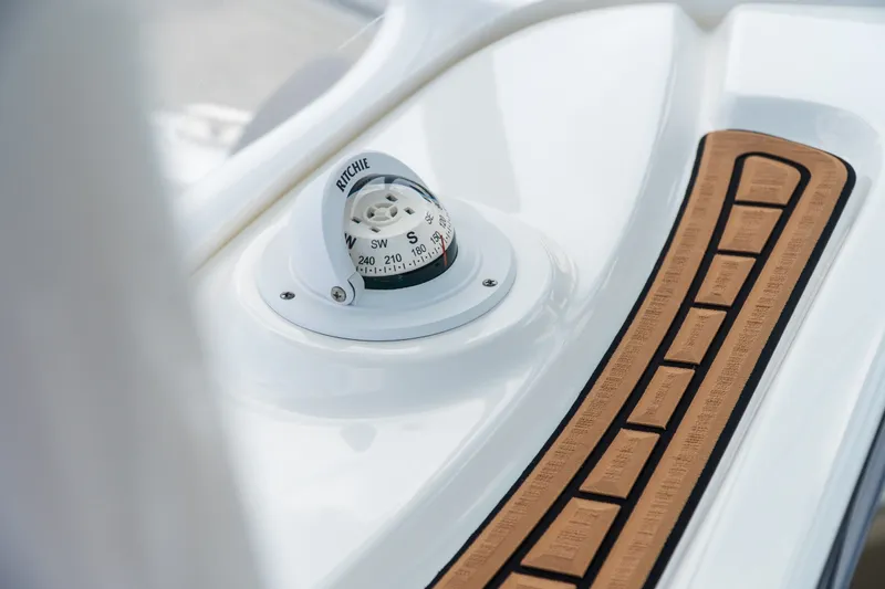 Slide: The Image of Compass on 2021 Tidewater 2300 Carolina Bay boat dashboard with teak accents. - 31