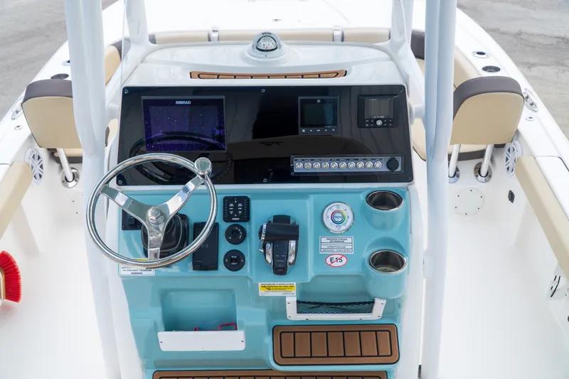 Slide: The Image of 2021 Tidewater 2300 Carolina Bay boat console with steering wheel and navigation controls. - 18