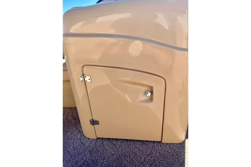 Slide: The Image of 2013 South Bay 417 CR boat storage compartment with beige finish and secure latch. - 18