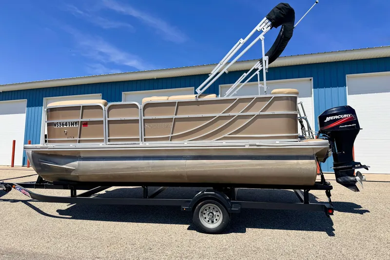 Slide: The Image of 2013 South Bay 417 CR pontoon boat on trailer, parked near blue building. - 3