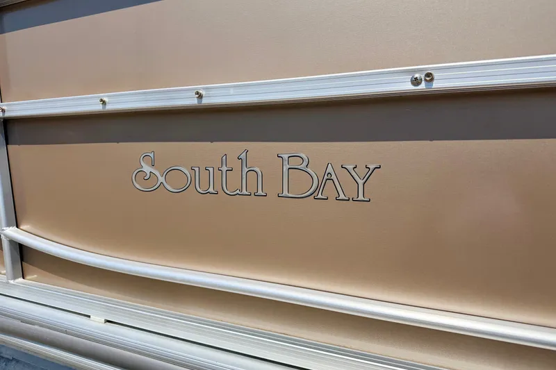 Slide: The Image of South Bay 417 CR 2013 boat logo on beige paneling. - 11